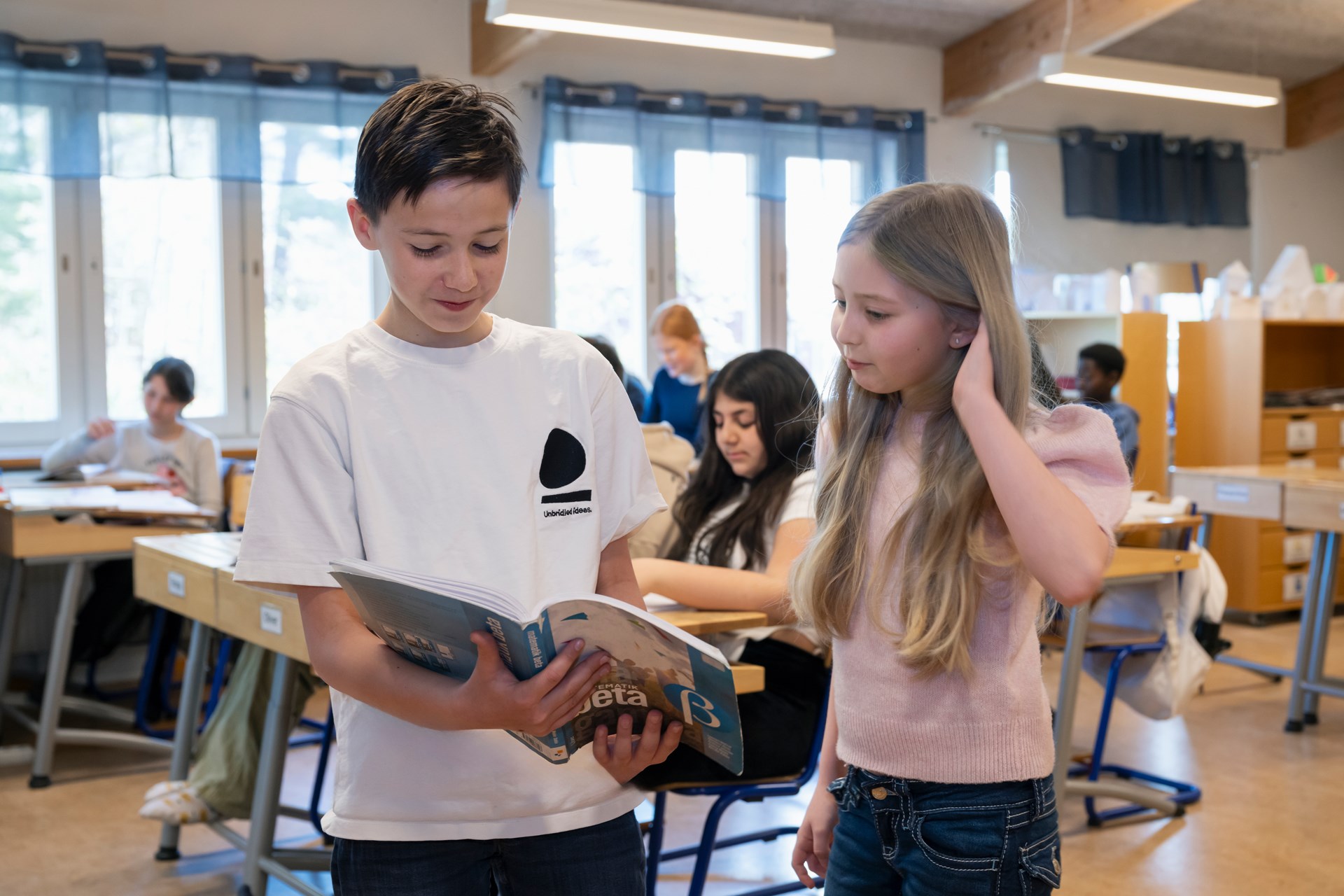 Två elever läser en bok