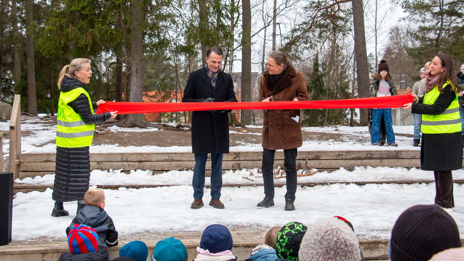 Två personer klipper ett rött invigningsband