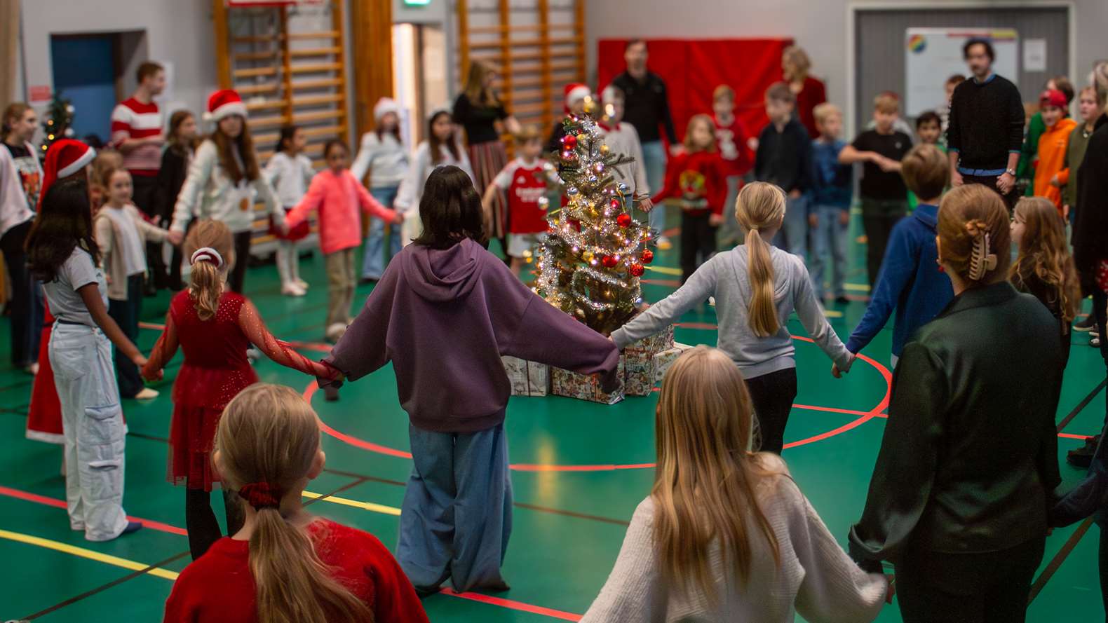 Elever i ring håller hand och dansar