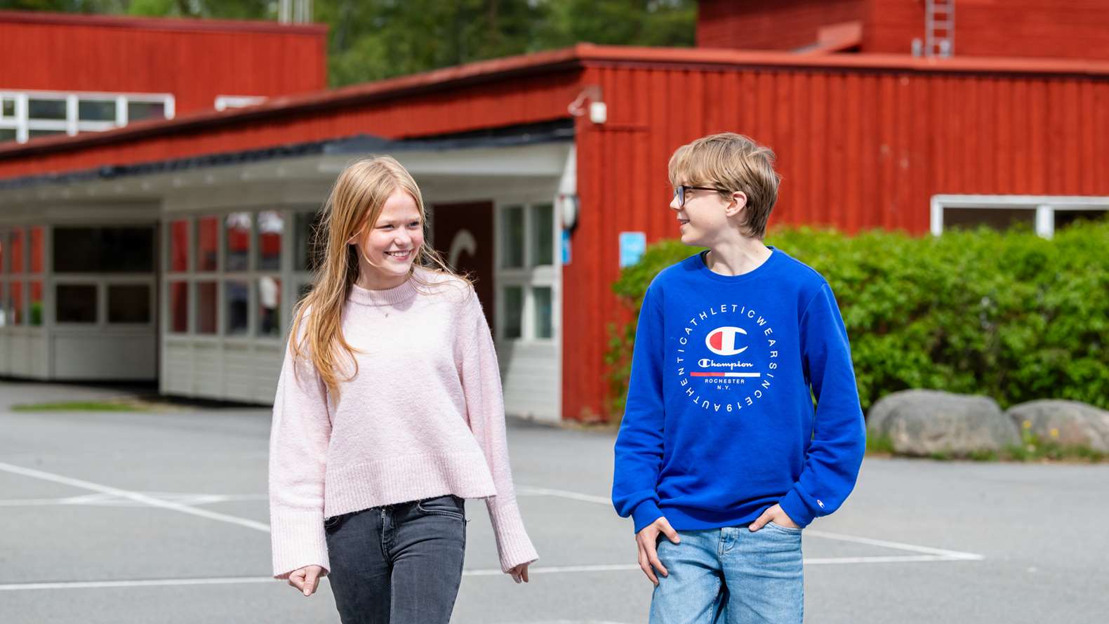 En tjej och en kille går på skolgården