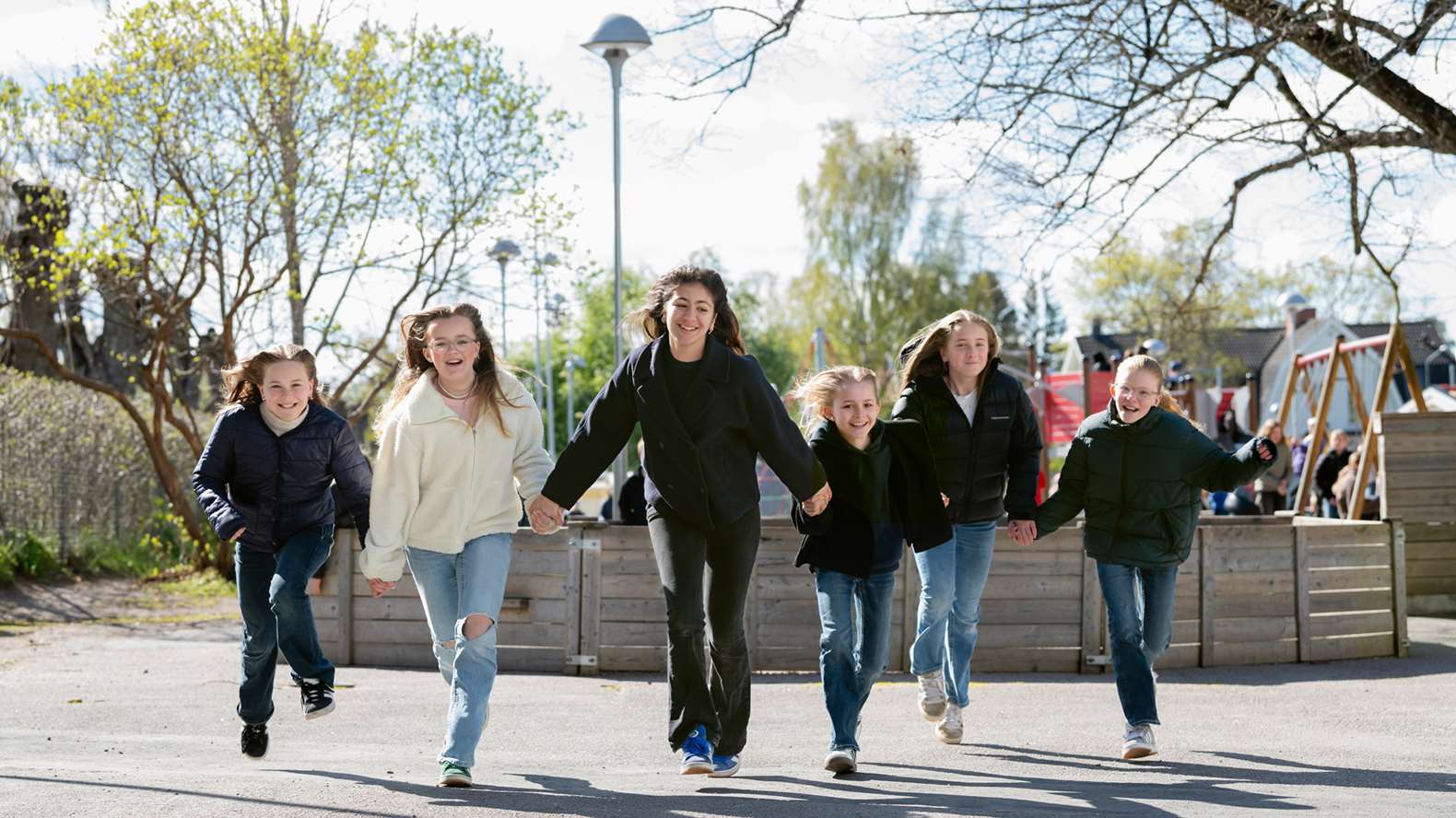 Barn springer på rad på skolgård
