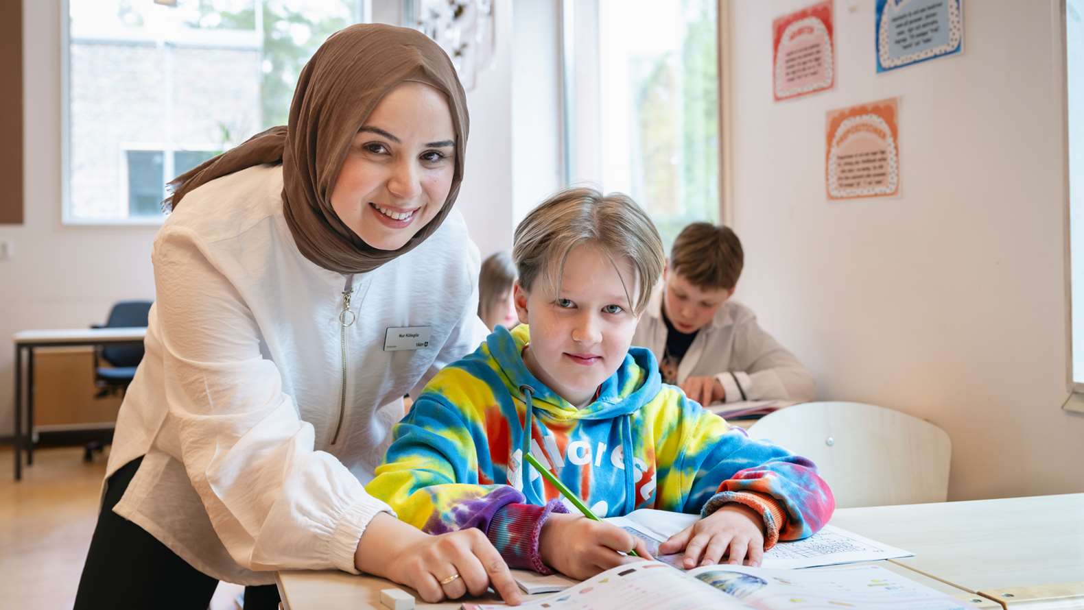 En lärare och en elev vid skolbänken