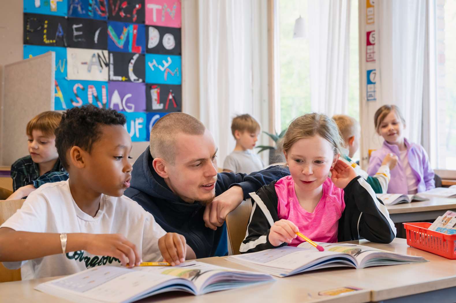 En lärare hjälper två elever i klassrummet