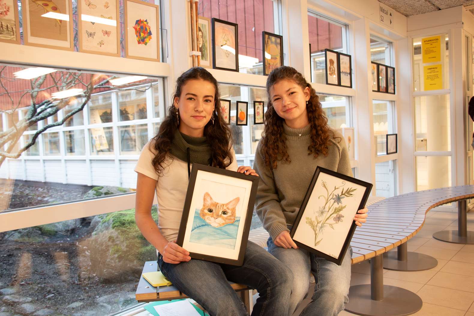 Två elever visar upp konst