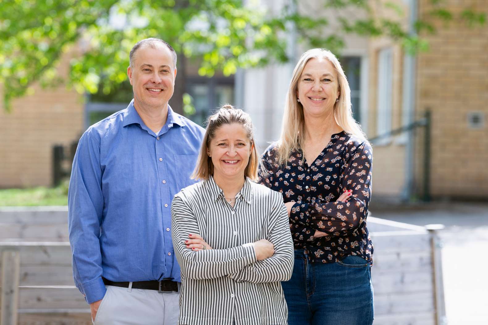 Tre personer poserar för ett foto