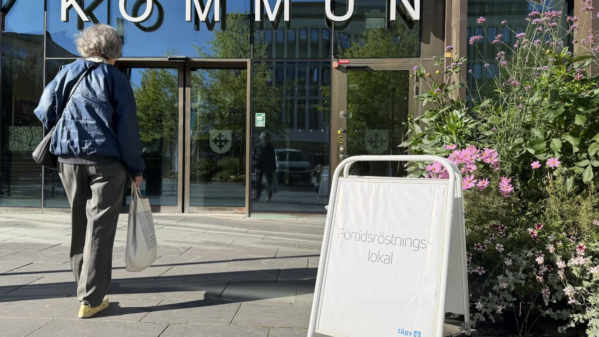 En person på väg in i Täby kommunhus.