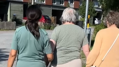 Tre personer promenerar utomhus.